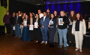 Absolventenjahrgang Heilerziehungsassistenz der Fachschule vor der Bühne im fideljo